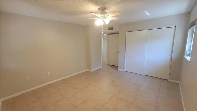 an empty room with a ceiling fan and a bathroom