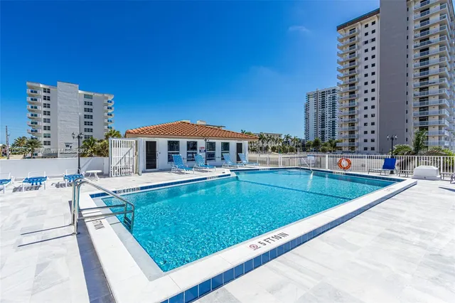 a view of swimming pool with chairs in front of house