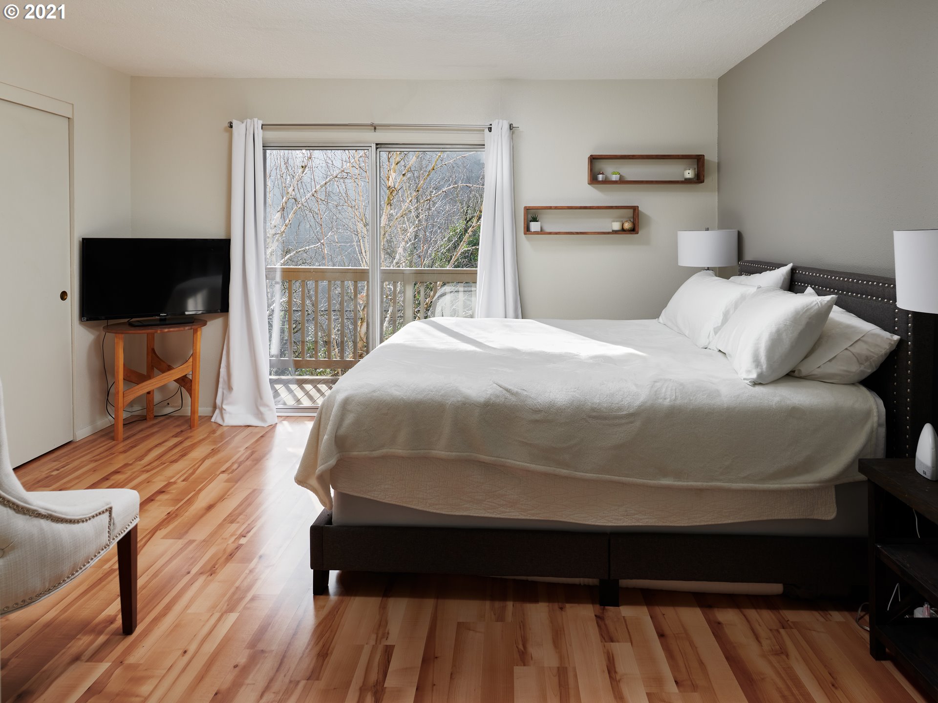 851 Southwest Broadway Drive, Unit 51 Portland, OR 97201 - Photo 10 of 19 a bedroom with a bed and a flat tv screen on dresser