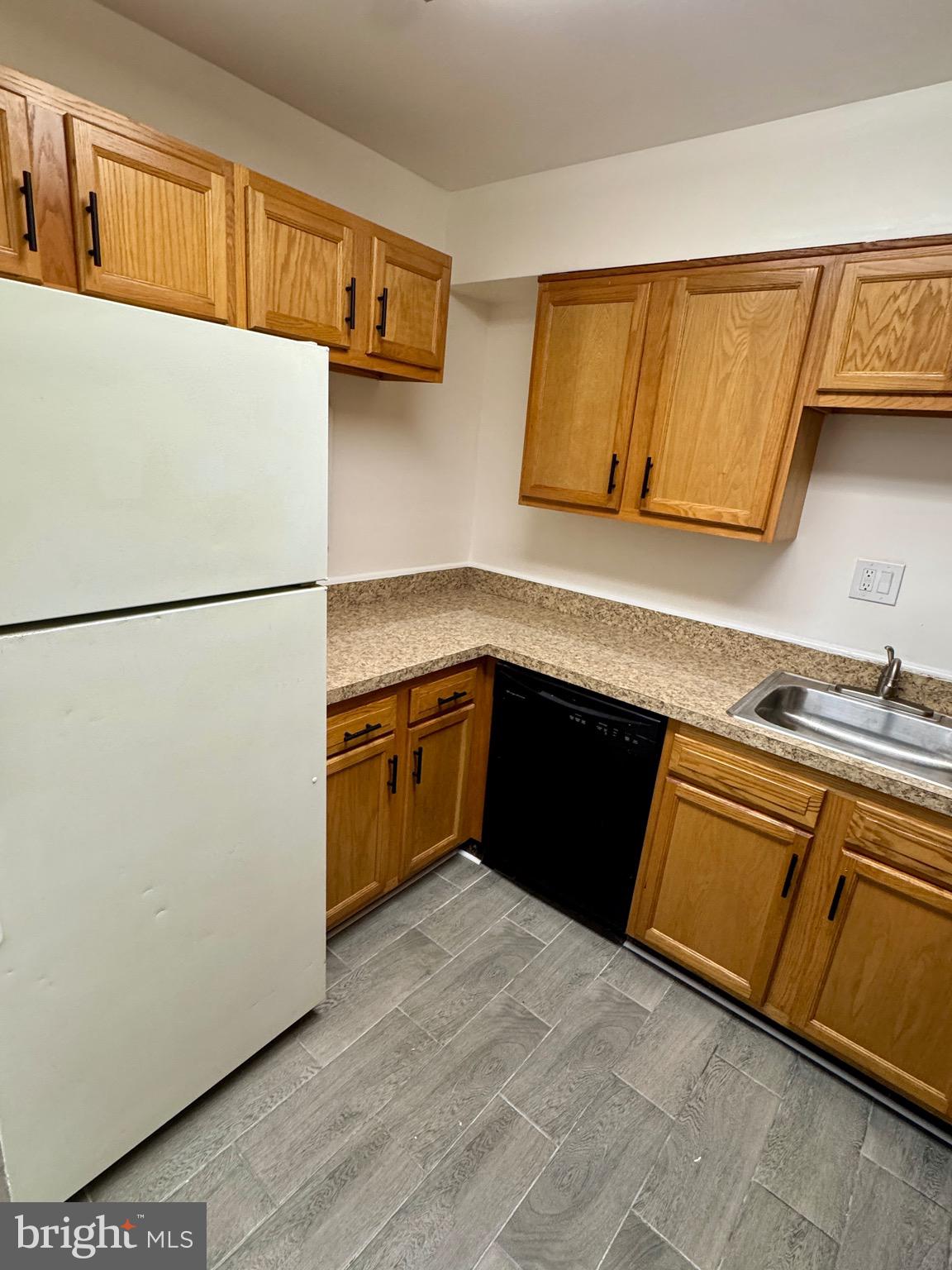 3811 Swann Road, Unit 102 Suitland, MD 20746 - Photo 4 of 10 a kitchen with stainless steel appliances granite countertop a refrigerator a sink and a stove