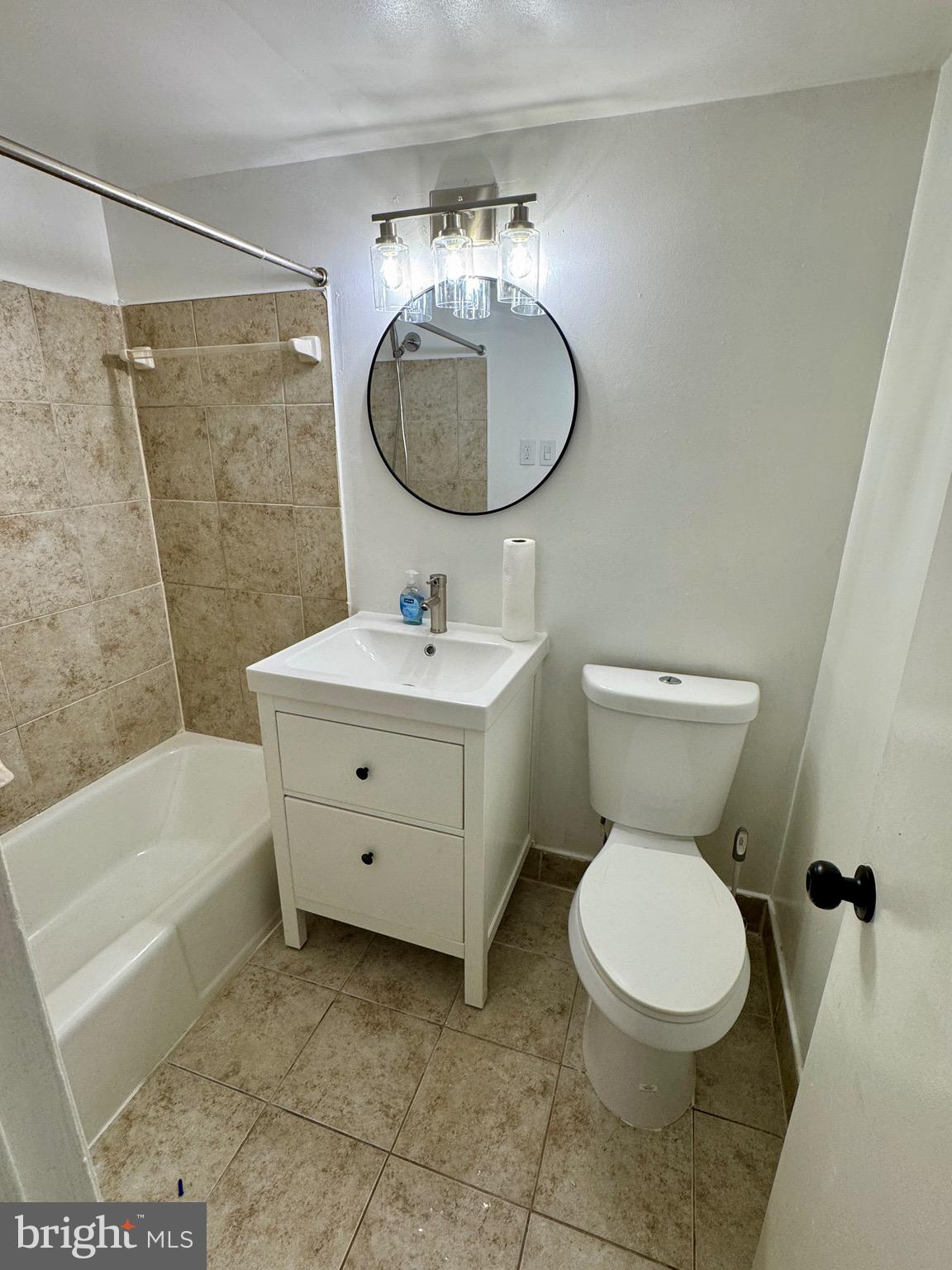 3811 Swann Road, Unit 102 Suitland, MD 20746 - Photo 9 of 10 a bathroom with a toilet a sink and a mirror