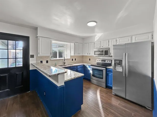 a kitchen with granite countertop wooden cabinets and sink