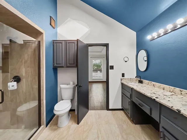 a bathroom with a granite countertop sink toilet and shower