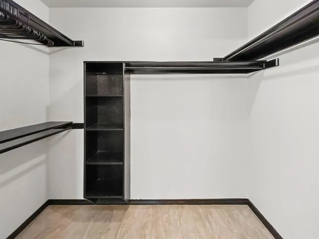 a view of walk in closet with empty racks