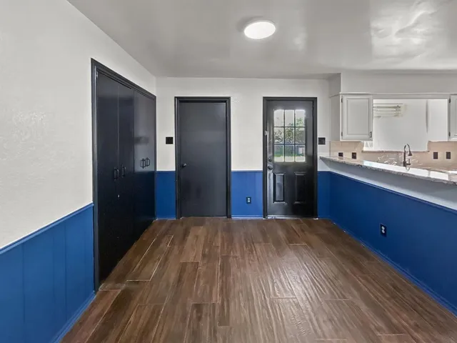 a kitchen with stainless steel appliances granite countertop a stove a sink dishwasher a refrigerator and white cabinets