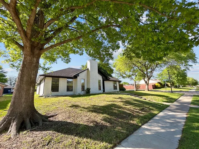 a view of a house with a tree in front of it