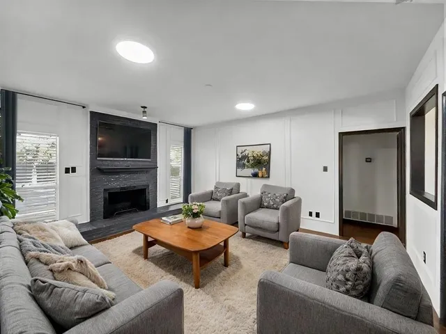 a living room with furniture a fireplace and a flat screen tv