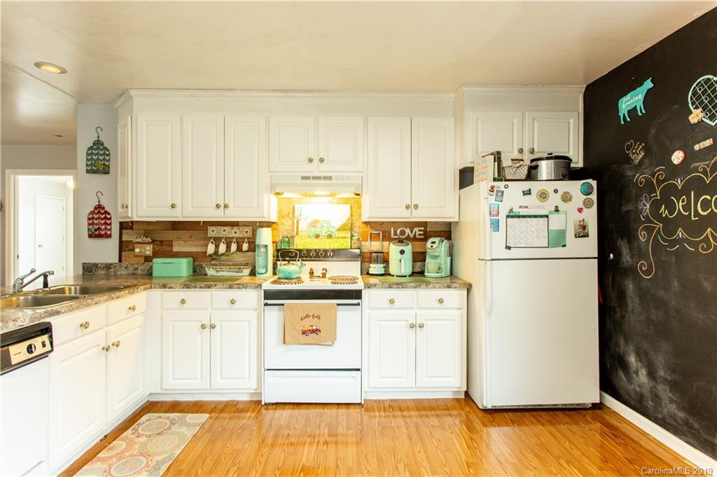 5520 Barrier Road Concord, NC 28025 - Photo 16 of 35 a kitchen with stainless steel appliances granite countertop a refrigerator a stove a sink and white cabinets with wooden floor