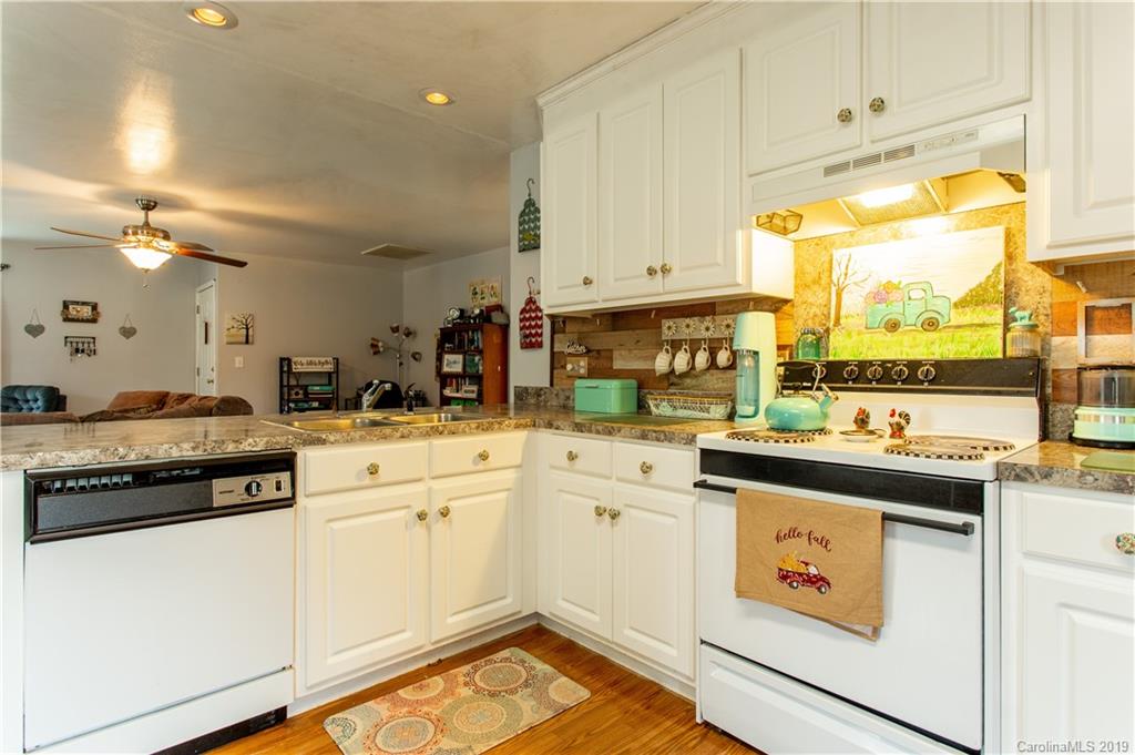 5520 Barrier Road Concord, NC 28025 - Photo 20 of 35 a kitchen with a stove a sink and white cabinets with wooden floor