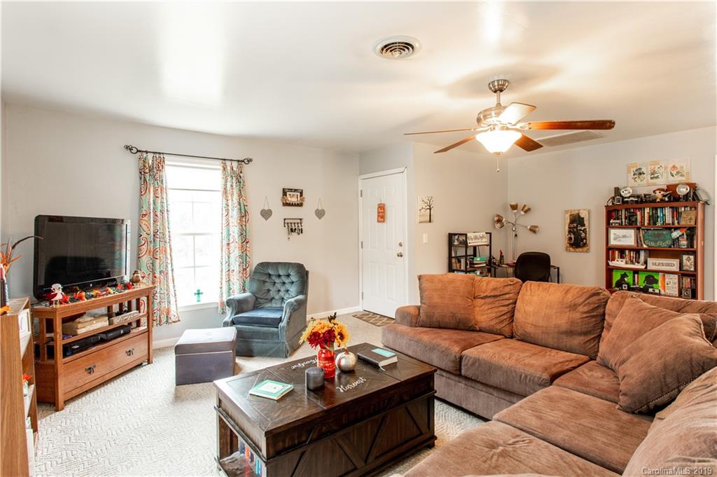 5520 Barrier Road Concord, NC 28025 - Photo 10 of 35 a living room with furniture a fireplace and a flat screen tv