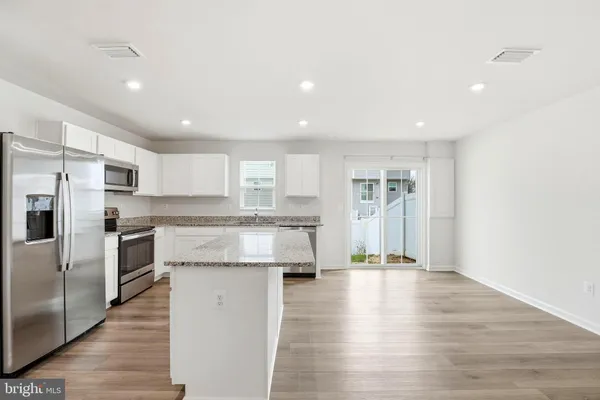 a kitchen with granite countertop a sink window and cabinets