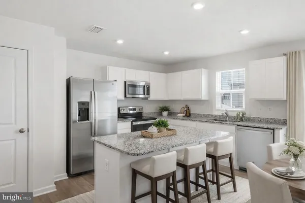 a kitchen with granite countertop kitchen island cabinets and refrigerator