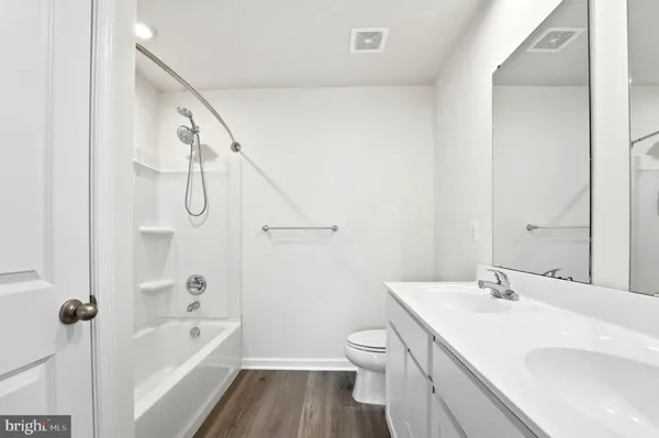 a bathroom with a double vanity sink toilet and a mirror