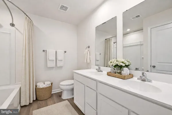a bathroom with a double vanity sink toilet and a mirror