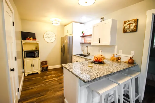 a view of deck with table and chairs under wooden roof with potted plants