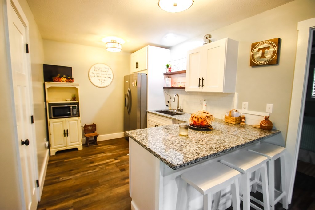 608 Lakeview Road Walling, TN 38587 - Photo 38 of 68 a kitchen with granite countertop kitchen island stainless steel appliances a refrigerator sink and cabinets
