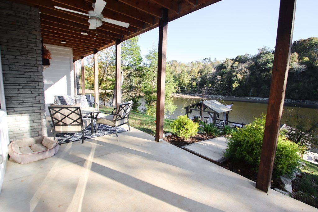 608 Lakeview Road Walling, TN 38587 - Photo 44 of 68 a view of a patio with table and chairs potted plants with wooden floor and fence