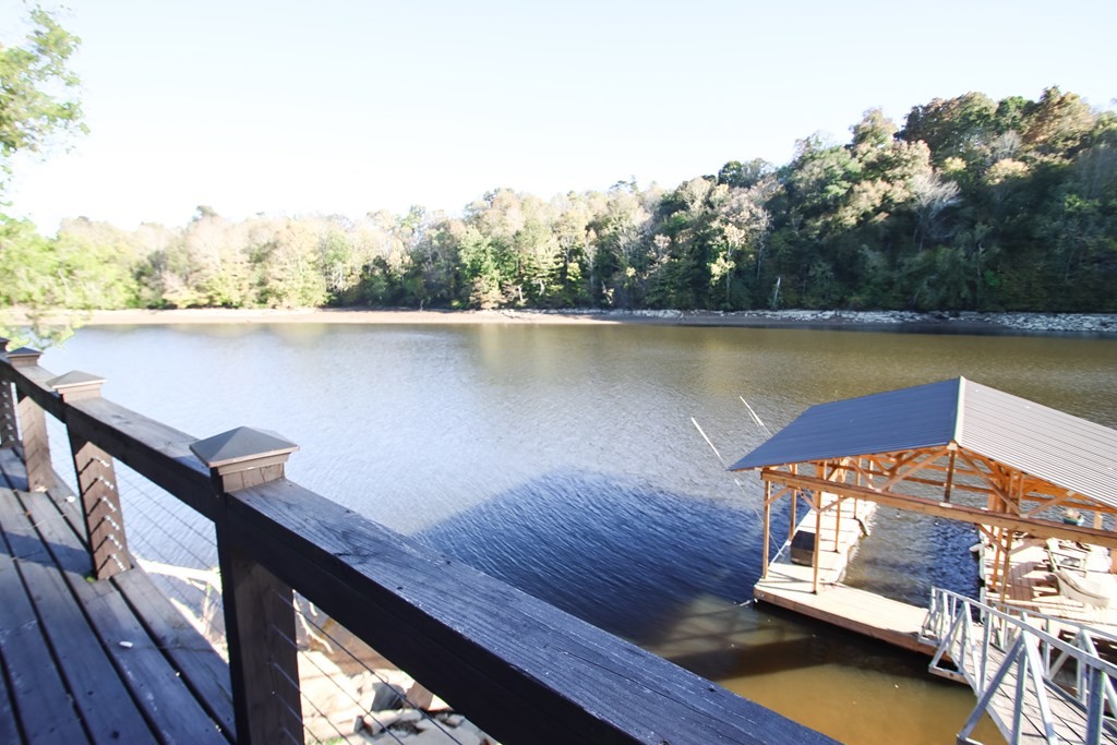 608 Lakeview Road Walling, TN 38587 - Photo 53 of 68 a view of a roof deck with table and chairs a barbeque with wooden floor and fence
