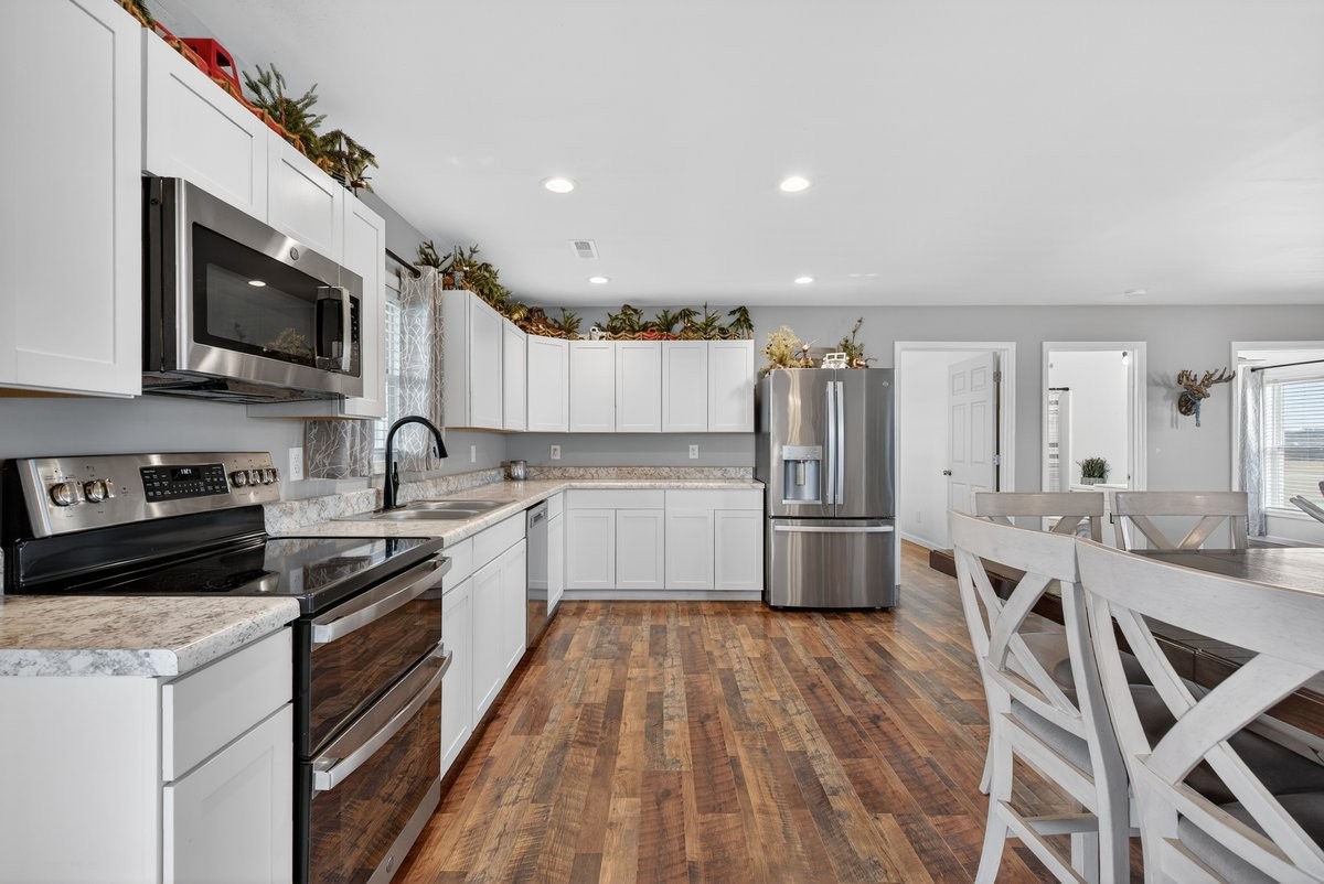 15419 Old Palestine Road Crofton, KY 42217 - Photo 19 of 53 a kitchen with stainless steel appliances granite countertop a stove top oven a sink dishwasher a refrigerator and white cabinets with wooden floor