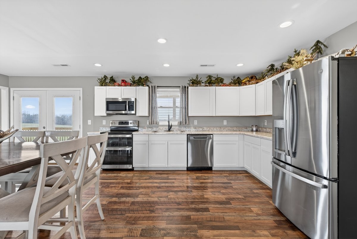 15419 Old Palestine Road Crofton, KY 42217 - Photo 20 of 53 a kitchen with granite countertop a refrigerator oven a sink and white cabinets