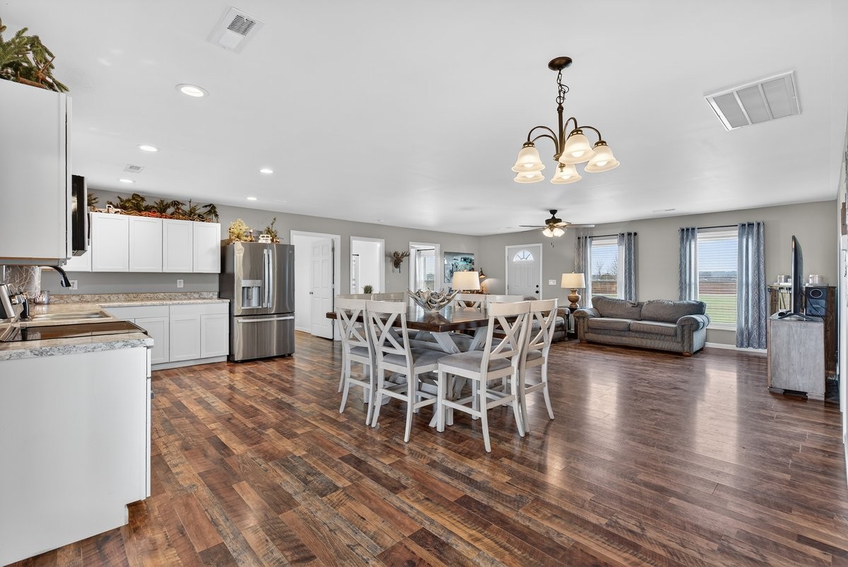 15419 Old Palestine Road Crofton, KY 42217 - Photo 22 of 53 a view of a dining room and livingroom with furniture wooden floor a chandelier