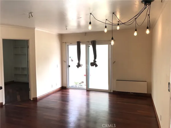 a view of a hallway with wooden floor and a bathroom