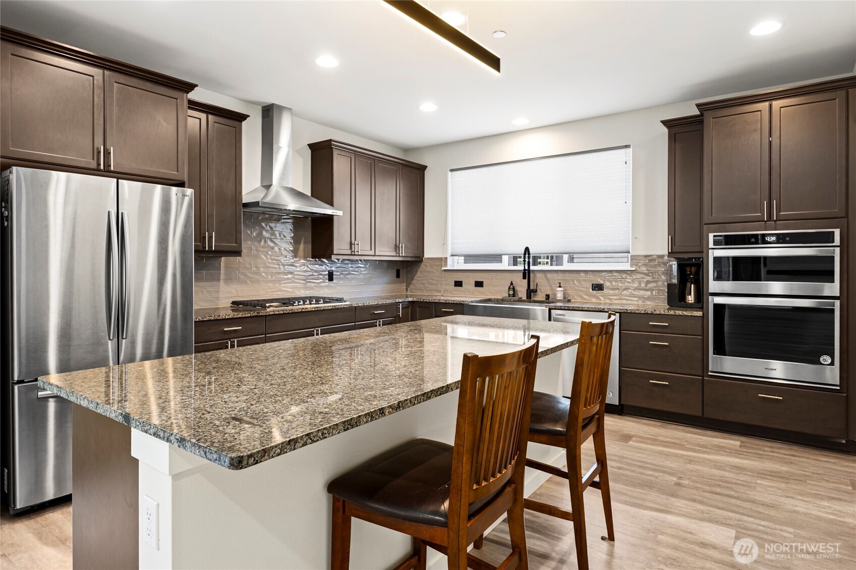 508 237th Street Southeast, Unit E Bothell, WA 98021 - Photo 13 of 35 a kitchen with granite countertop a center island stainless steel appliances cabinets and a counter top space
