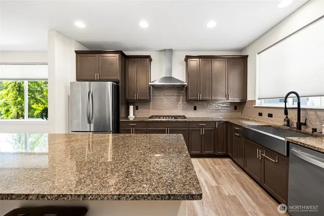 a kitchen with stainless steel appliances granite countertop a refrigerator sink and stove