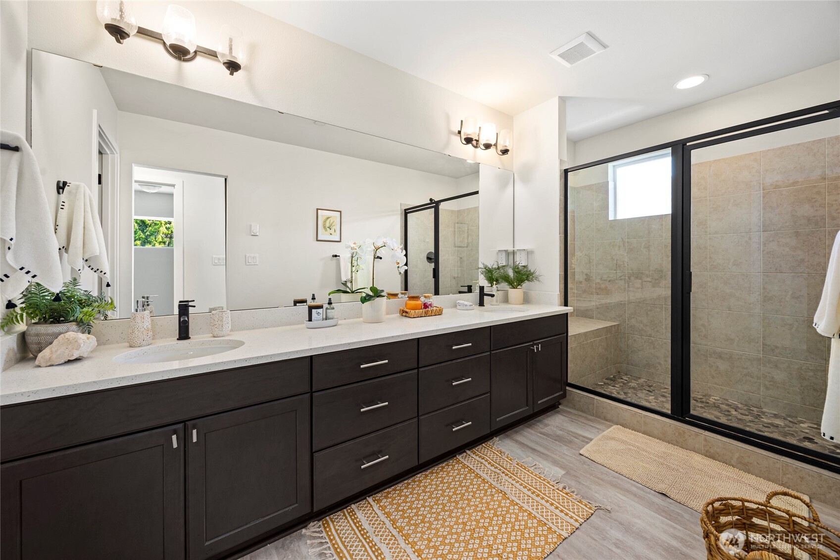 508 237th Street Southeast, Unit E Bothell, WA 98021 - Photo 24 of 35 a bathroom with a double vanity sink a large mirror a shower and a bathtub