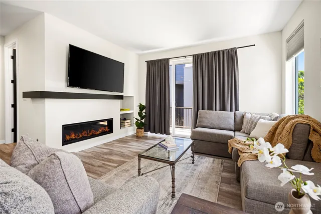 a living room with furniture a fireplace and a flat screen tv