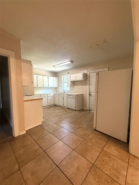 217 3rd St Pinehill Springhill, LA 71075 - Photo 16 of 23 Spacious kitchen featuring extensive cabinetry, ample counter space, a built-in dishwasher, and large format floor tiling