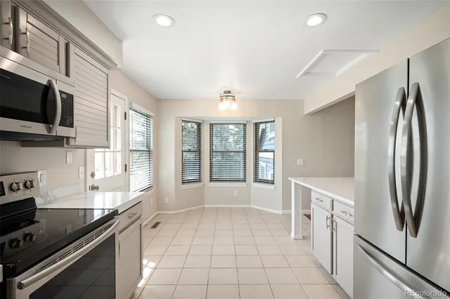 a large kitchen with stainless steel appliances granite countertop a refrigerator and a sink