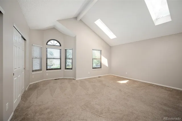 an empty room with windows and mirror