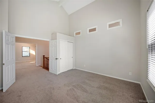 an empty room with windows and closet
