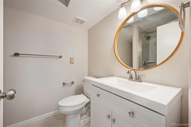 a bathroom with a sink a mirror a toilet and a mirror