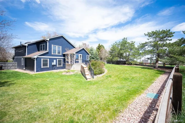 a view of a house with a big yard and large trees