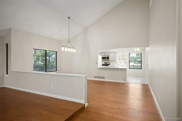 a view of a kitchen with wooden floor and a window