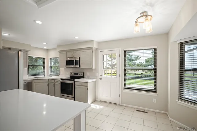 a kitchen with stainless steel appliances granite countertop a stove top oven a sink dishwasher a refrigerator and a refrigerator with wooden floor