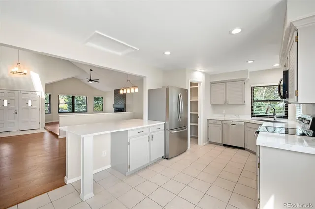 a large white kitchen with a stove a sink dishwasher and a refrigerator