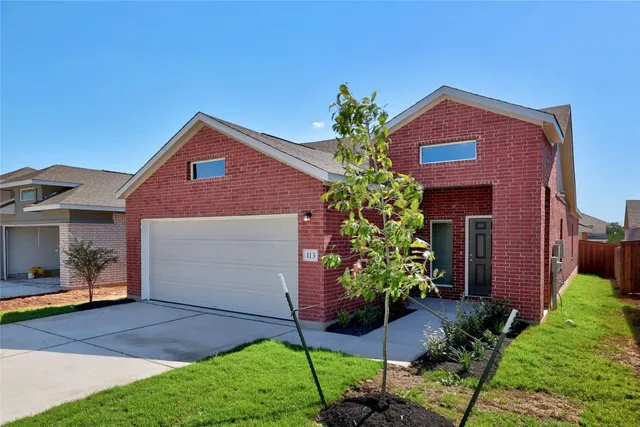 a view of a house with a yard and potted plants