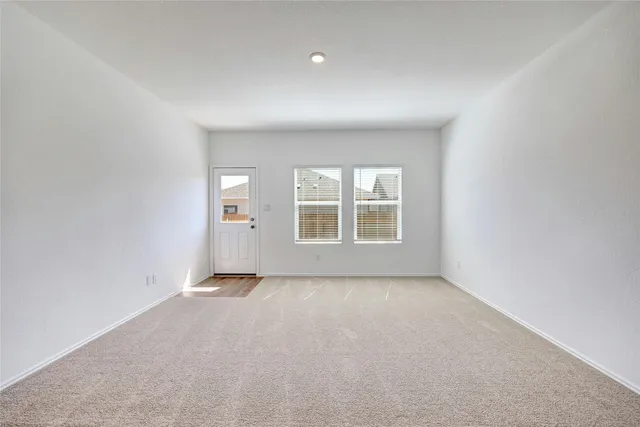 a view of a big room with windows and chandelier fan