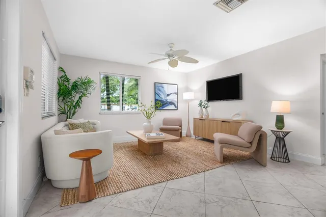 a living room with furniture a flat screen tv and a large window
