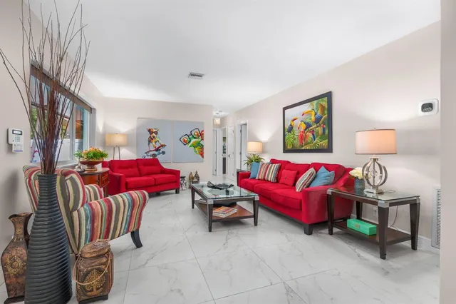 a living room with furniture a flat screen tv and a large window