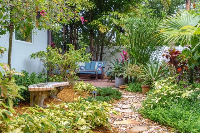 a view of house with yard and a trees