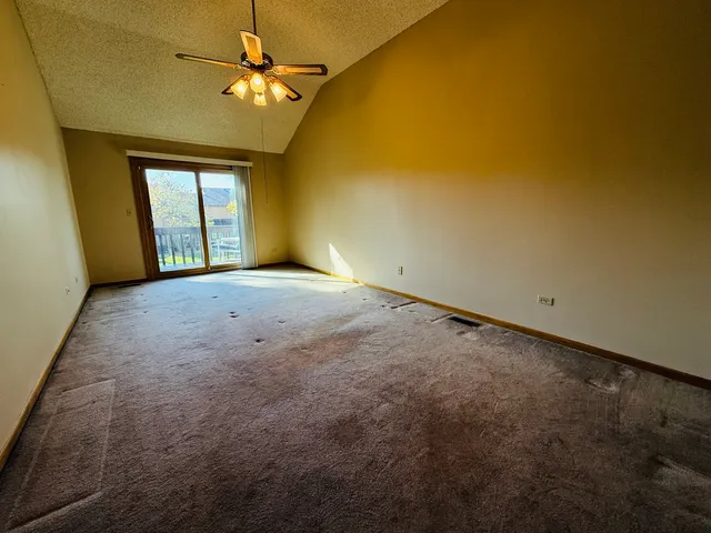 an empty room with windows and fan