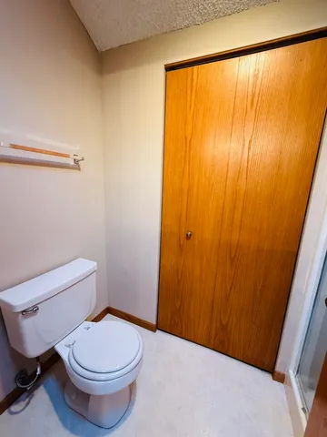 a white toilet sitting next to a shower
