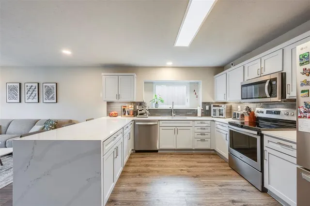 a kitchen with granite countertop a sink and steel appliances