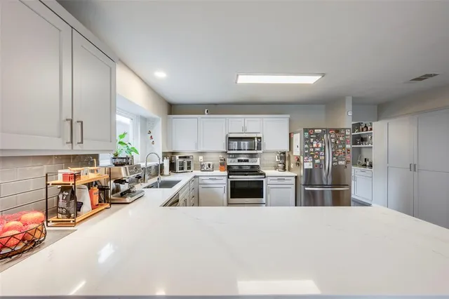 a kitchen with stainless steel appliances granite countertop a refrigerator stove and sink