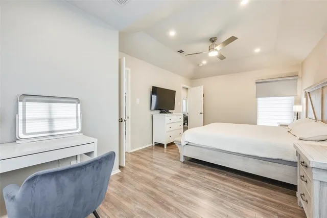 a bedroom with a large bed and a flat tv screen on dresser
