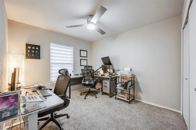 a view of a workspace with furniture and a window